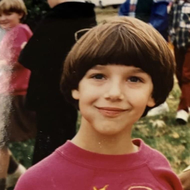 Holly as a young child, smiling outdoors