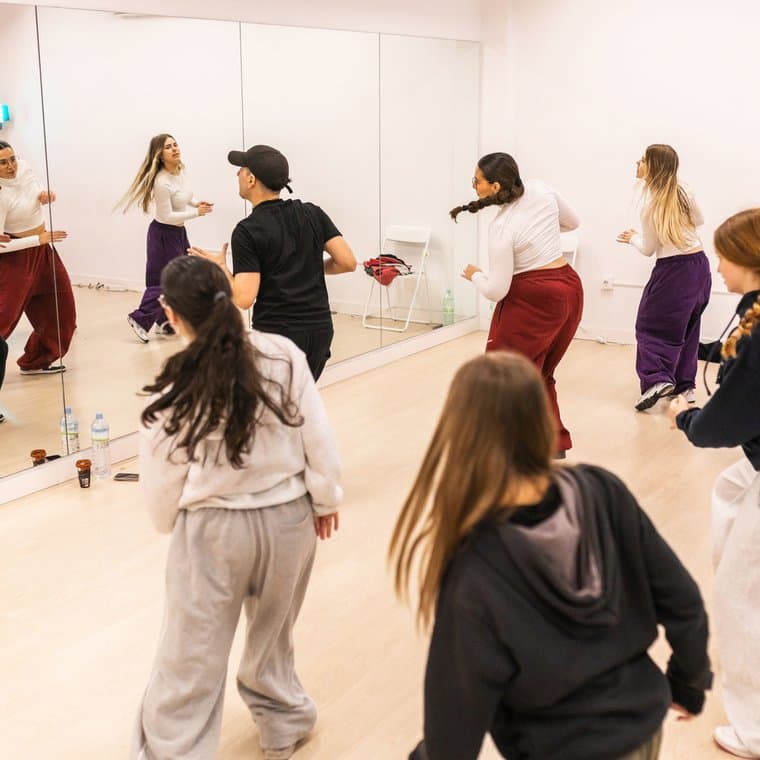 A group of teens learning choreography in a dance studio