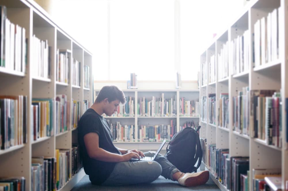 A student working on a laptop in a library